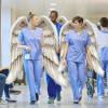 Tre sjukepleiarar med englevinger går nedover ein sjukehuskooridor